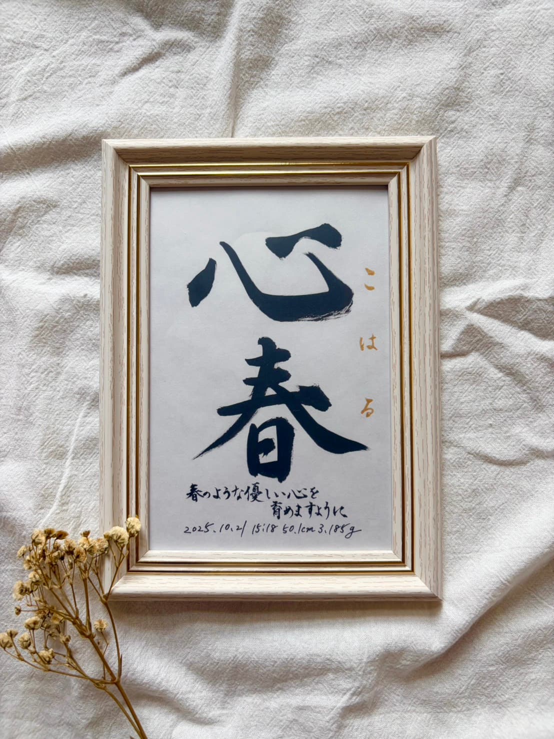 ベージュの木のフレームに入れた命名書